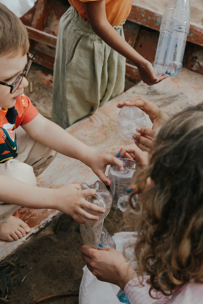 Young volunteers collect plastic bottles for recycling, learning teamwork and environmental responsibility.